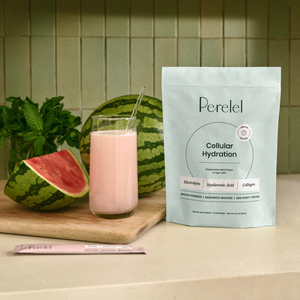 Glass of cellular hydration with watermelon and Perelel supplement package on a wooden board.