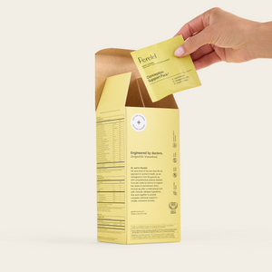 A hand lifts a daily sachet from an open box of Perelel Conception Support Pack.