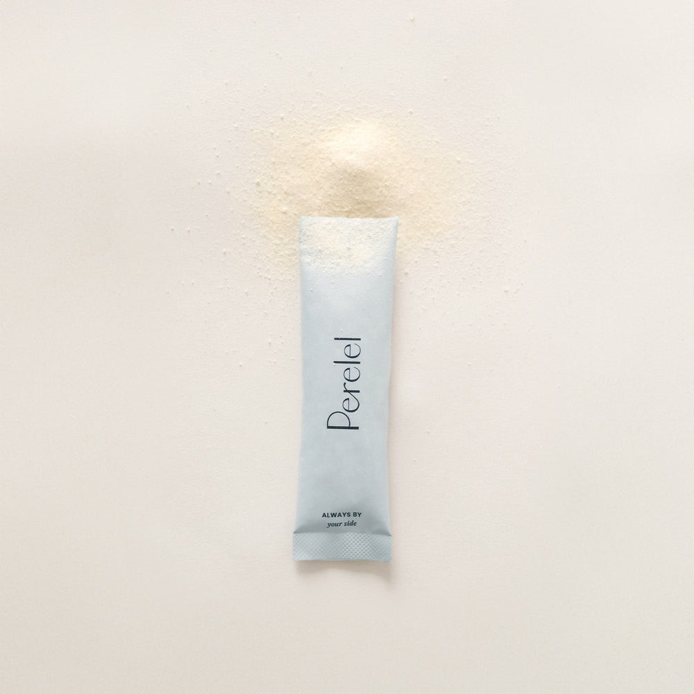 A single light blue travel stick of Perelel Hydration Powder on a warm off-white background with a small pile of fine powder above it. 