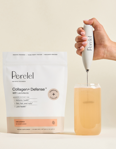 Hand using a Perelel frother in a glass of golden liquid beside a pouch of Perelel Collagen+ Defense with lactoferrin, labeled unflavored with no sugar added.