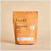 A pouch of Perelel Triple-Support Protein powder in Pumpkin Chai flavor, shown on a beige background. The packaging color is orange with black text and a white labeling. 