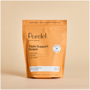 A pouch of Perelel Triple-Support Protein powder in Pumpkin Chai flavor, shown on a beige background. The packaging color is orange with black text and a white labeling. 