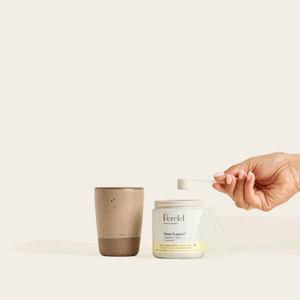 Sleep Support powder jar beside a mug, with a hand holding a scoop above the mug.