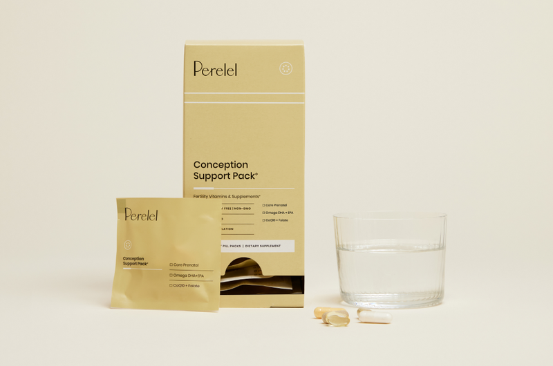 Perelel conception support pack with a glass of water and capsules on a light background